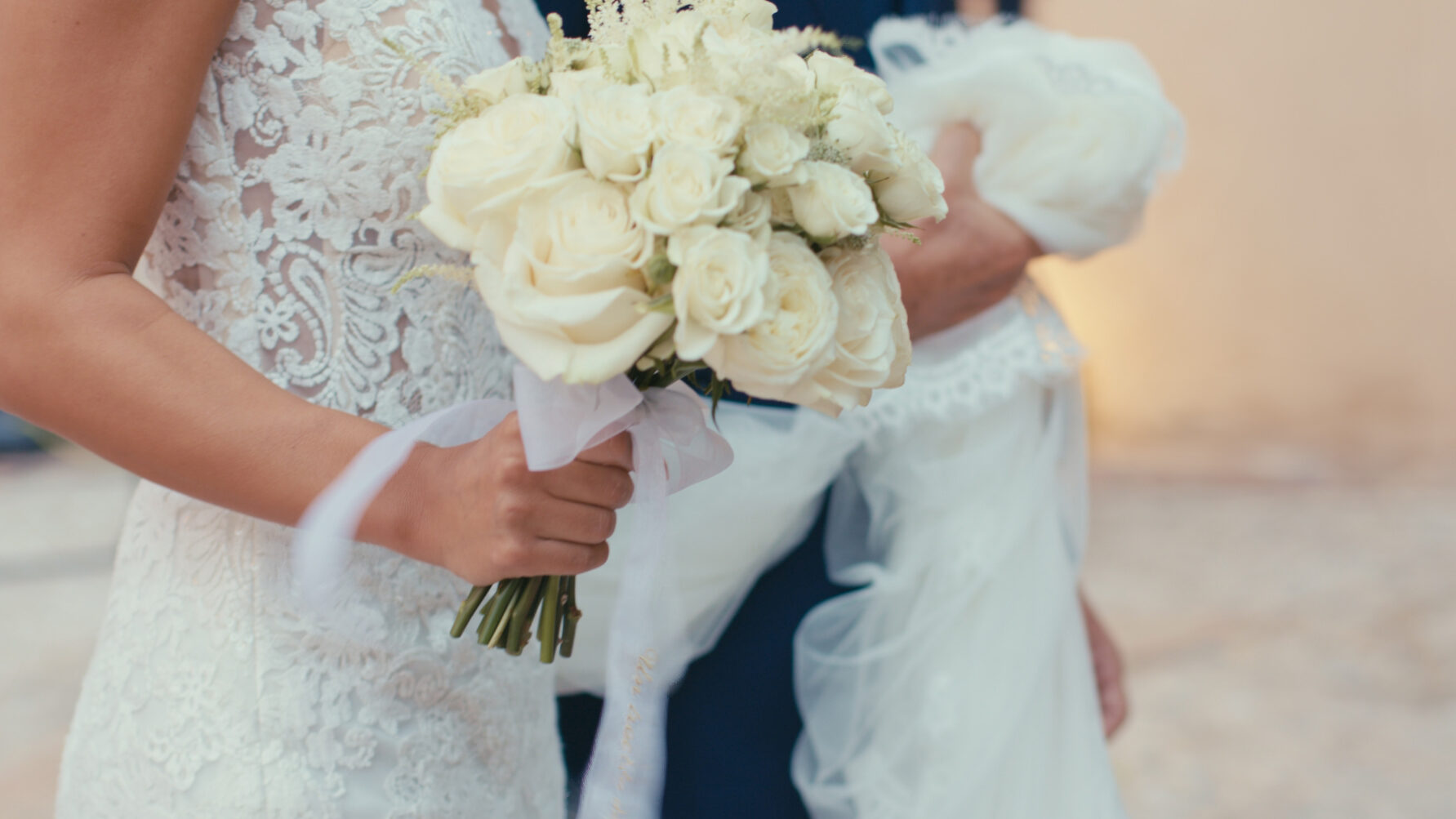 Novia sosteniendo su ramo blanco con flores frescas.