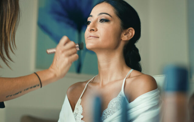 Maquilladora aplicando sombra de ojos a la novia.